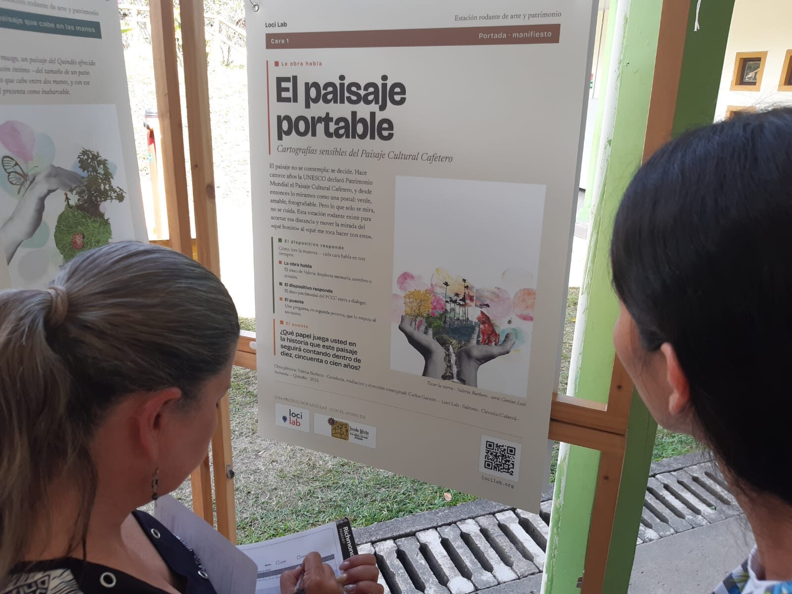 Asistentes leyendo la lámina portada-manifiesto de El Paisaje Portable